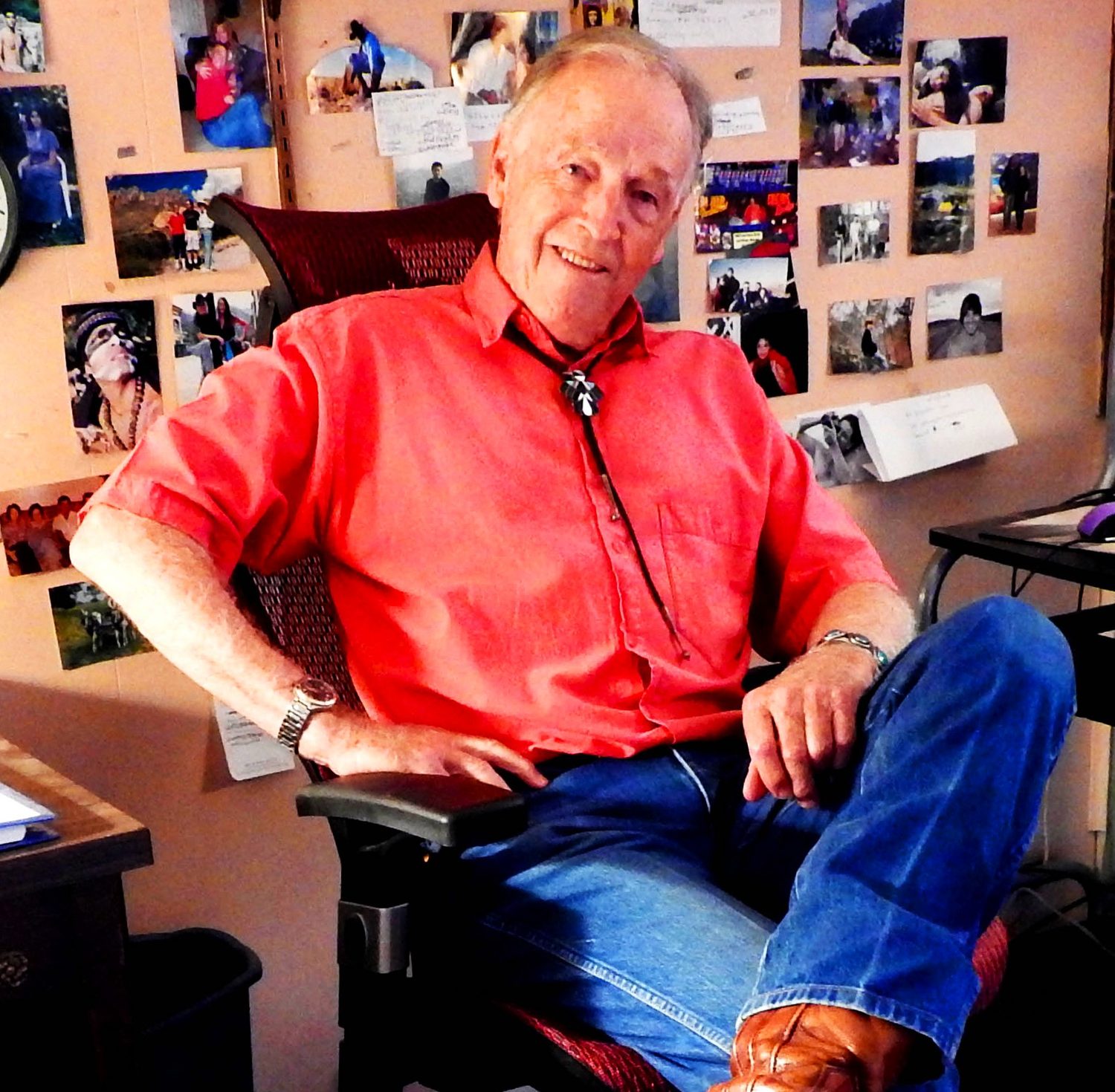 Ed Breeding in his studio in Las Cruces, a wall of photographs behind him