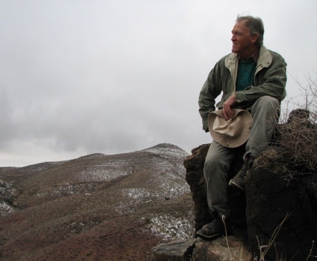 Ed Breeding on a ridgeline above Las Cruces, hat in hand